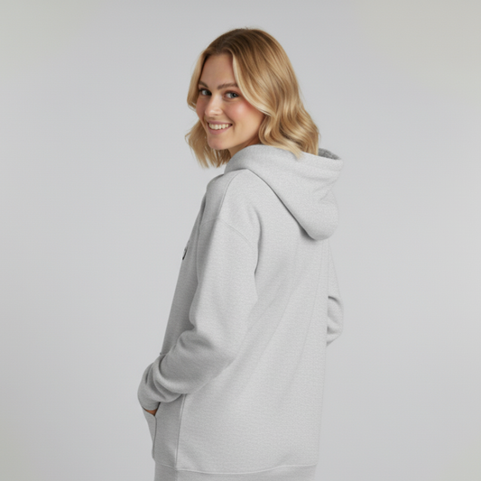 Woman wearing a gray hoodie against a plain background