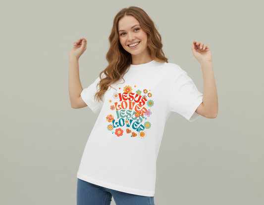 Woman wearing a white t-shirt with colorful text design on a plain background