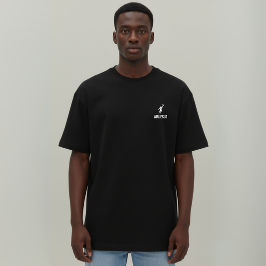 Person wearing a black t-shirt with a logo on a plain background