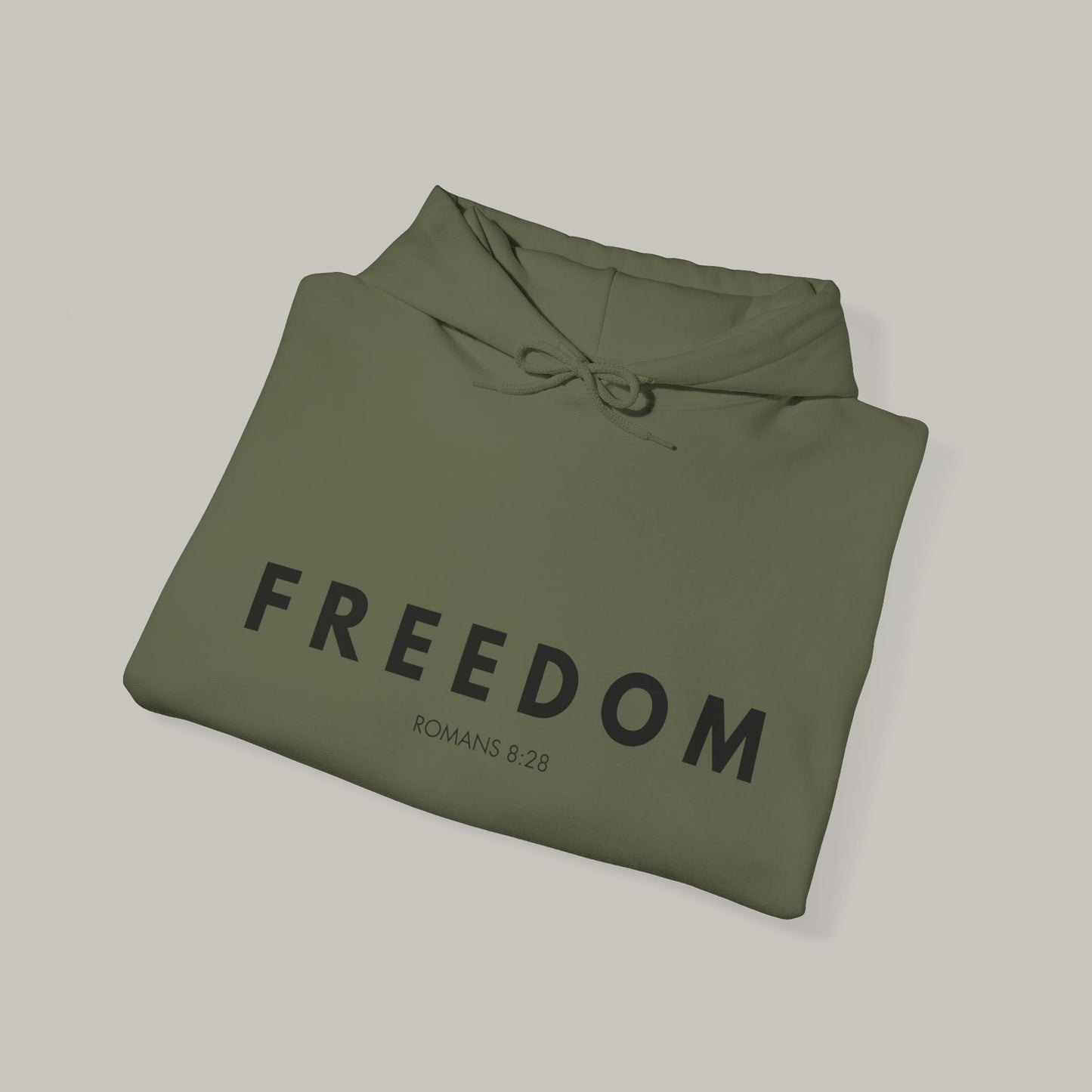 Folded green hoodie with 'FREEDOM' text on a light gray background