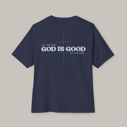 Navy blue t-shirt with 'GOD IS GOOD ALL THE TIME' text on a gray background
