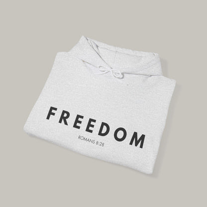 Folded gray hoodie with 'FREEDOM' text on a beige background