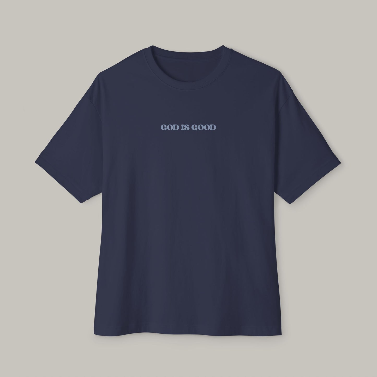 Navy blue t-shirt with 'GOD IS GOOD' text on a gray background