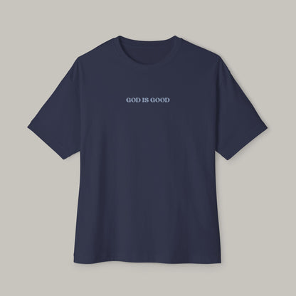 Navy blue t-shirt with 'GOD IS GOOD' text on a gray background
