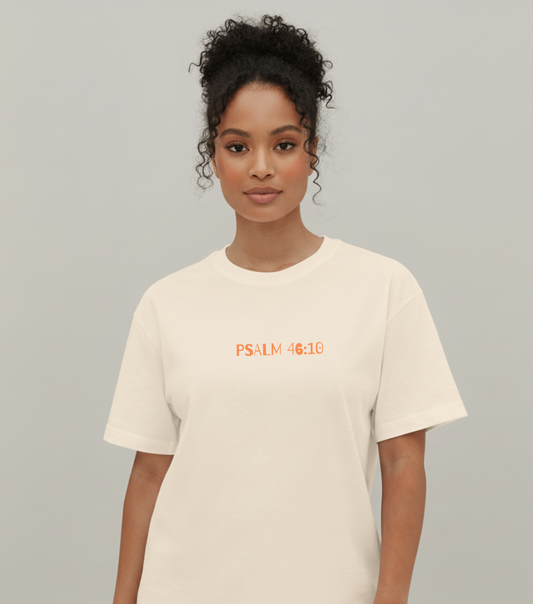 Person wearing a beige t-shirt with 'PSALM 46:10' text on a plain background