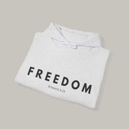 Folded gray hoodie with 'FREEDOM ROMANS 8:29' text on a beige background