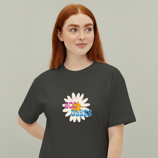 Person wearing a black t-shirt with a colorful flower design and 'God Bless' text on a plain background