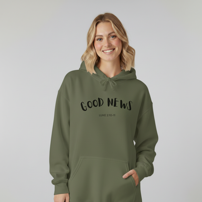 Person wearing a green hoodie with 'GOOD NEWS' text on a plain background