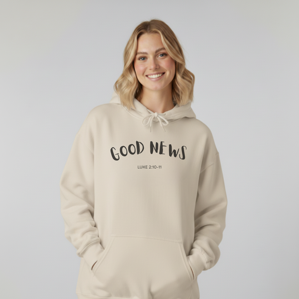Woman wearing a beige hoodie with 'GOOD NEWS' text on a plain background