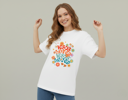 Woman wearing a white t-shirt with colorful text design on a plain background