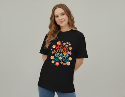Woman wearing a black t-shirt with colorful 'Jesus Loves Jesus Loves' design on a plain background