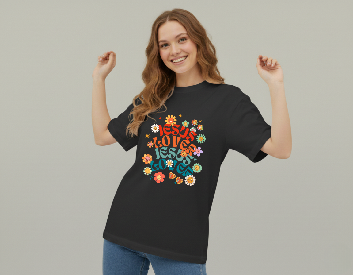 Woman wearing a black t-shirt with colorful text and floral designs on a plain background