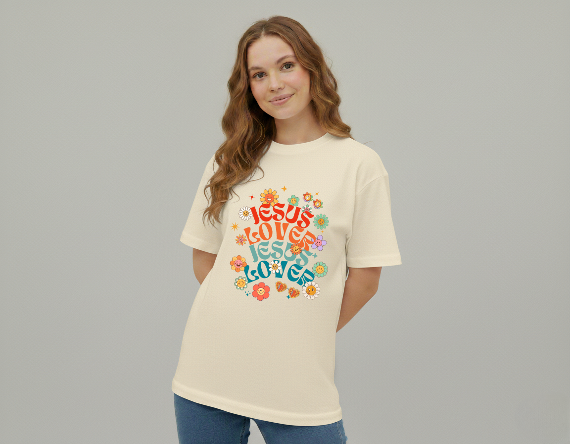 Woman wearing a cream t-shirt with colorful 'Jesus Loves Jesus Loves' design on a gray background