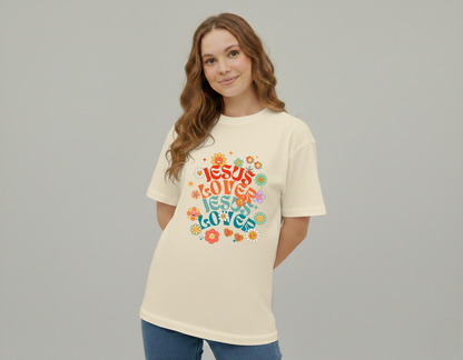 Woman wearing a cream t-shirt with colorful 'Jesus Loves Jesus Loves' design on a gray background