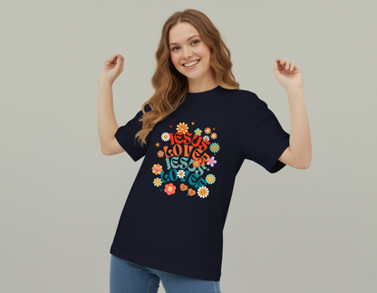 Woman wearing a black t-shirt with colorful text and flowers on a plain background