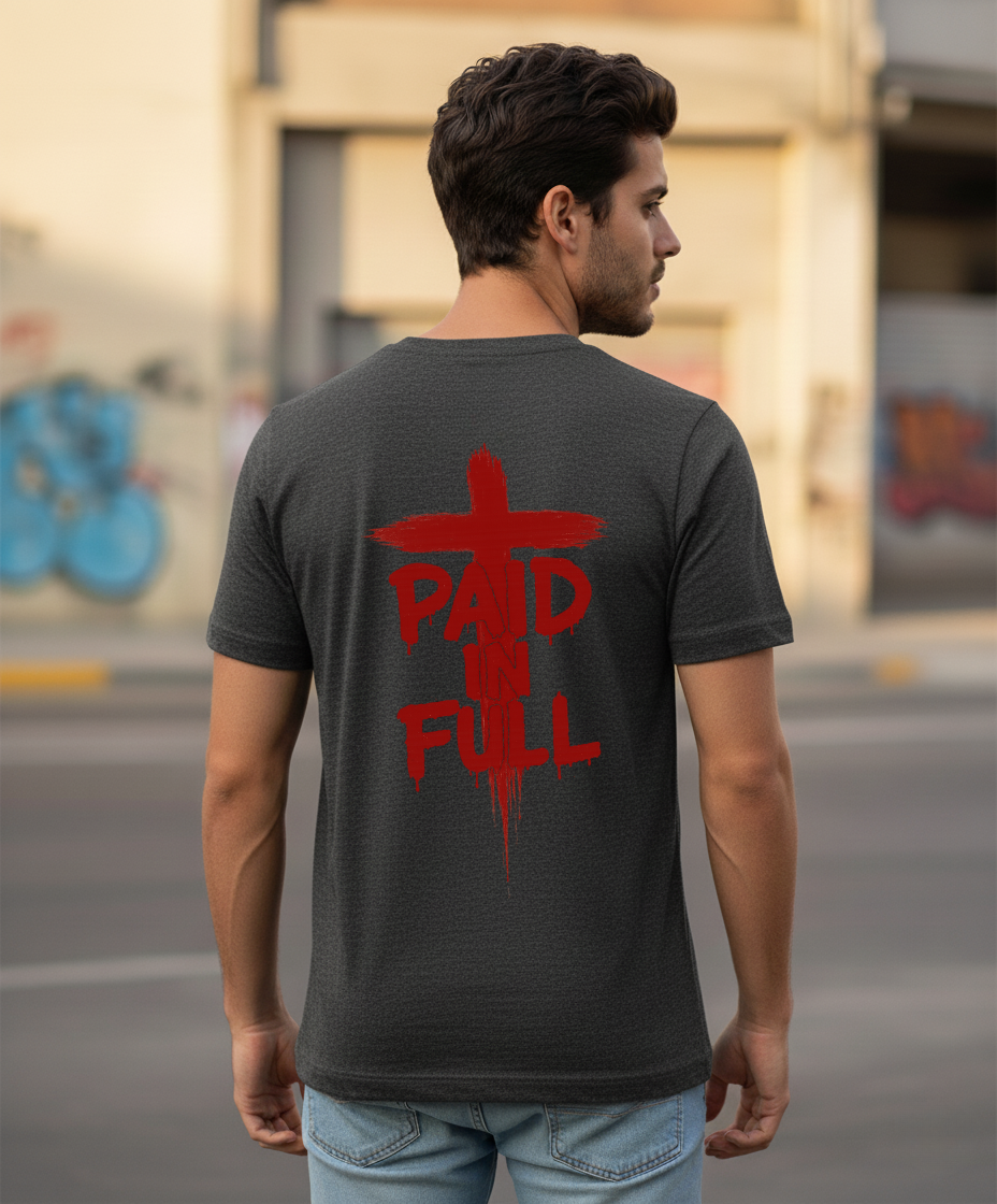 Man wearing a black t-shirt with red text  'Paid In Full' on the back, standing on a street.