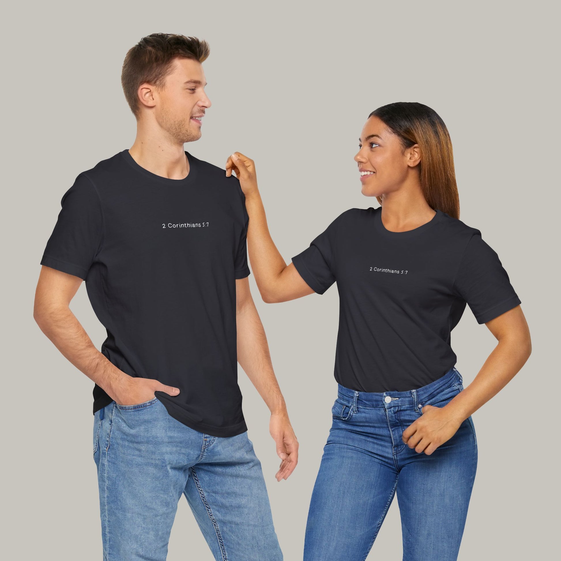 Two people wearing black t-shirts with text on a gray background